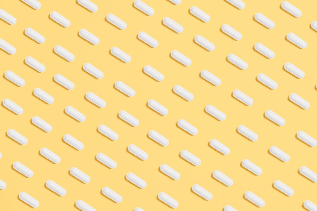 white capsules on yellow background