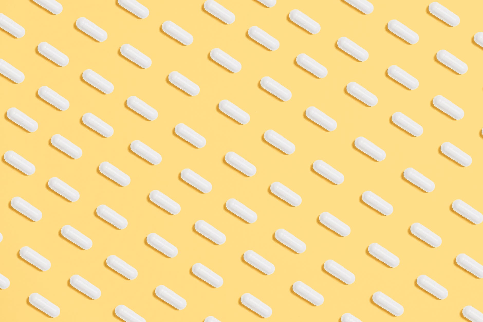 white capsules on yellow background